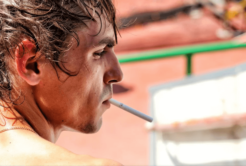 man smoking, which causes sore gums
