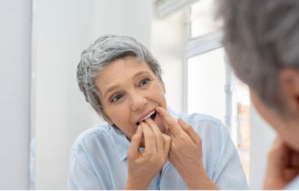 woman checking her teeth -common mistakes in oral care